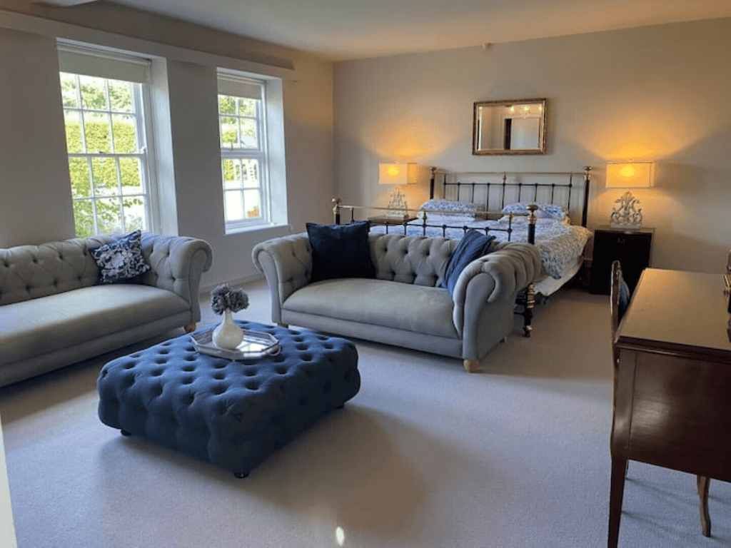 Elegant bedroom with sofas and queen-sized bed