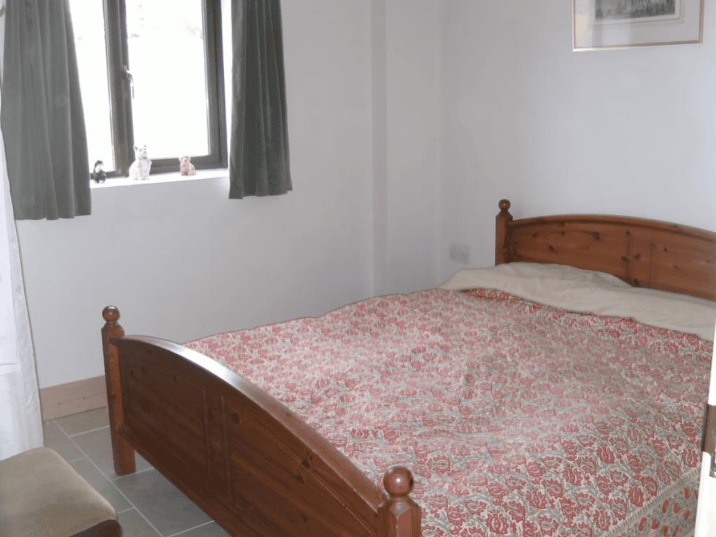 Cozy bedroom with floral bedspread and wooden bed frame