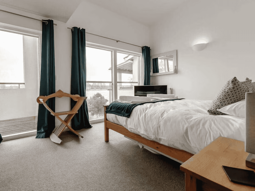 Modern bedroom with wooden furniture and large window