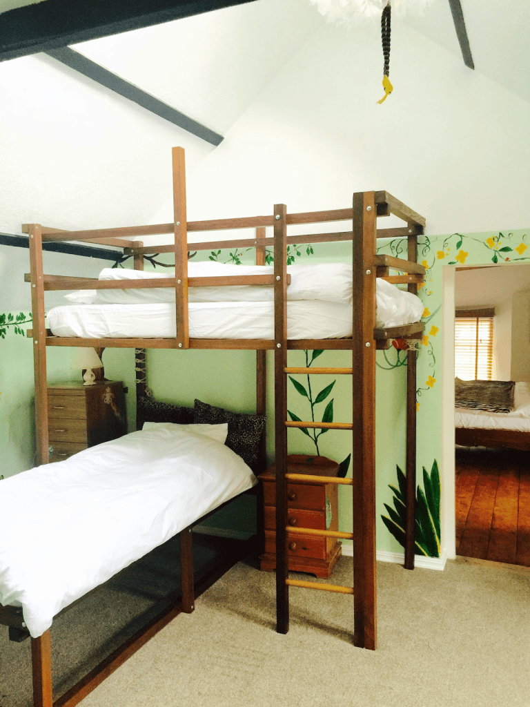 Wooden bunk bed in a bright, plant-themed bedroom