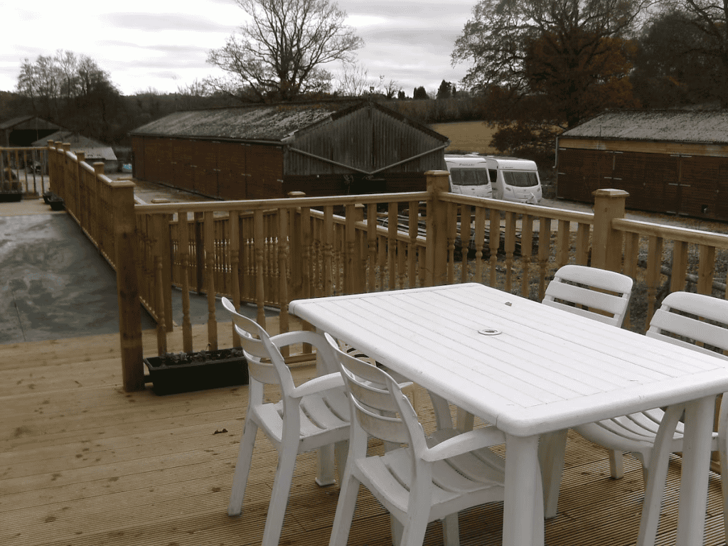 Outdoor wooden deck with white table and chairs