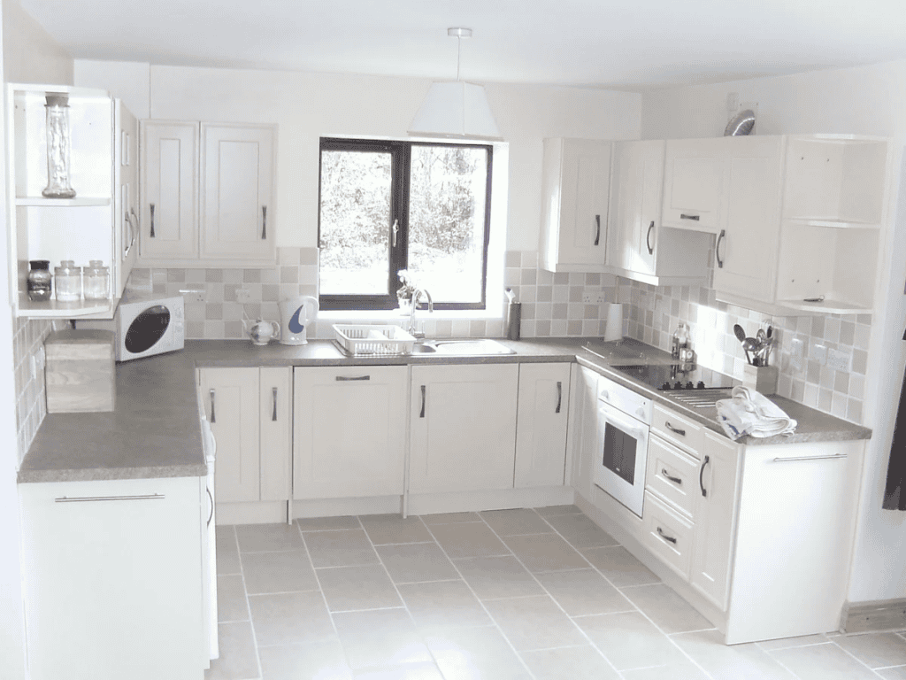 Bright modern kitchen with beige cabinets and tiled backsplash