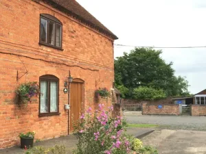 Brick cottage with flower baskets and courtyard