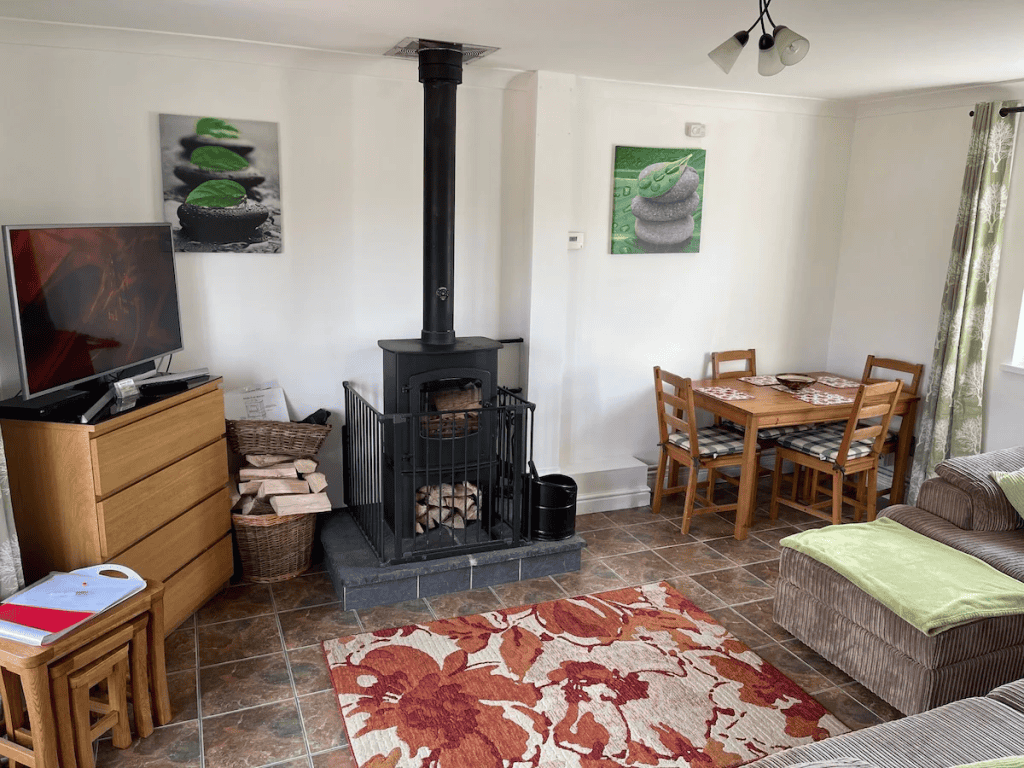 Cozy living room with fireplace, TV, and dining area