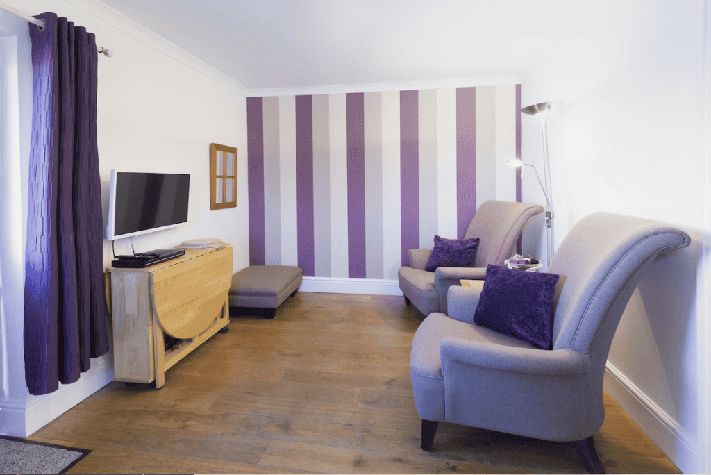 Modern living room with striped purple wall and furniture