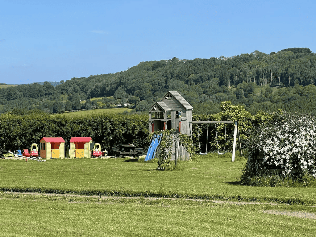 Playground with slides and swings in lush green landscape