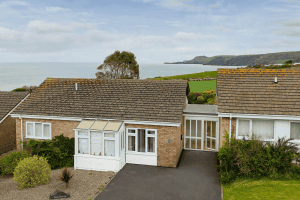 Coastal bungalows overlooking green hills and sea