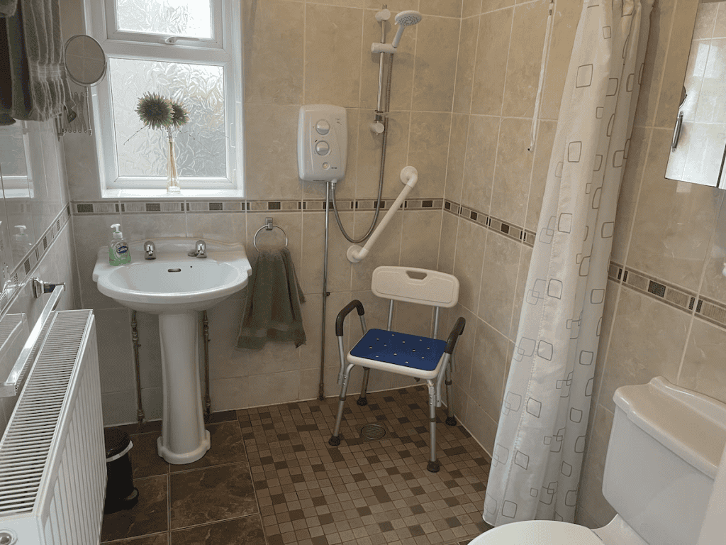 Accessible bathroom with shower chair and handrails