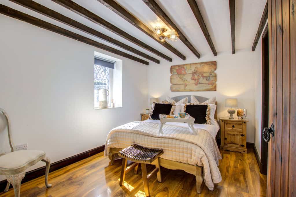 Cozy rustic bedroom with wooden beams and elegant decor