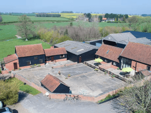 Aerial view of rural brick farm complex with courtyard