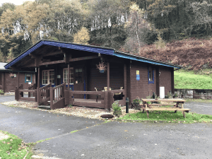 Rustic wooden cabin with benches in forest setting