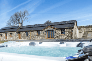 Stone cottage with hot tub under sunny sky