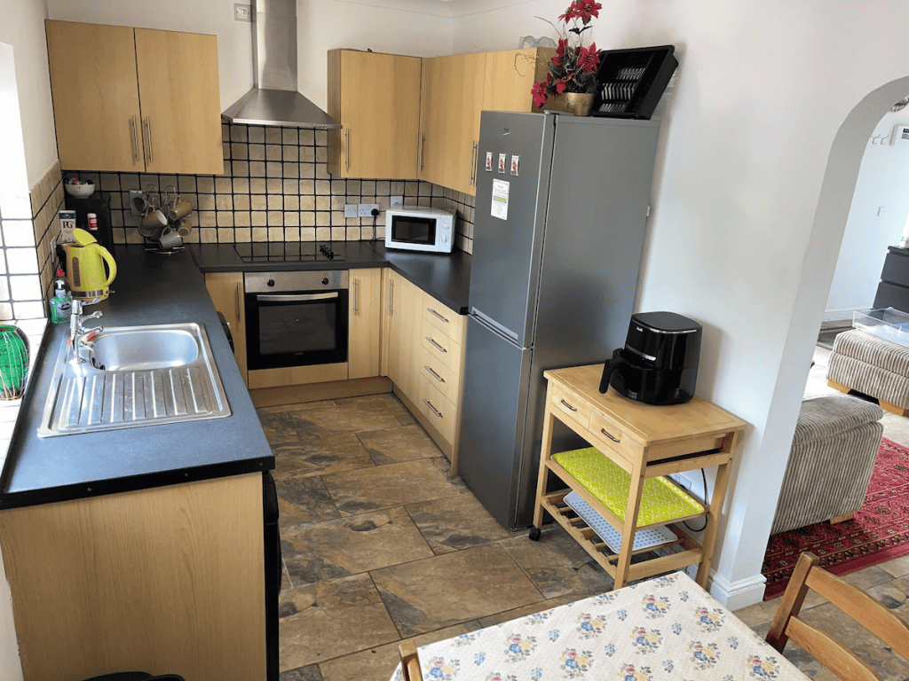 Modern kitchen with wooden cabinets and stone tile flooring