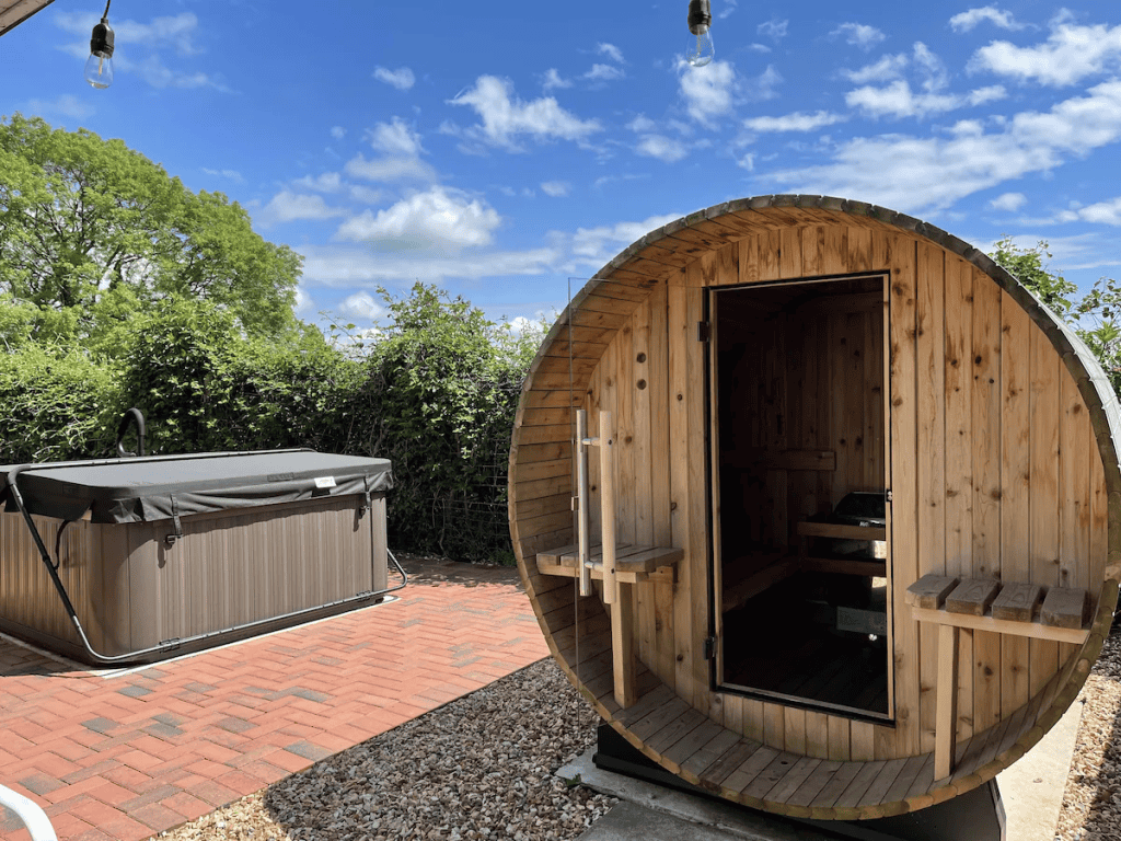 Outdoor sauna and hot tub in a lush garden setting