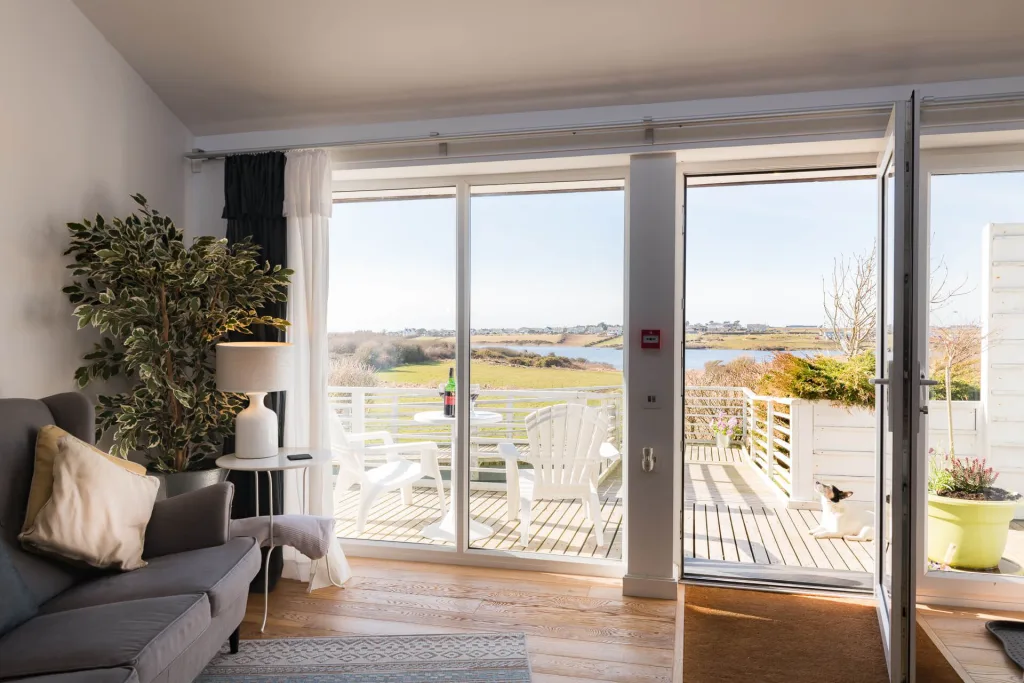 Bright living room opens to scenic coastal view