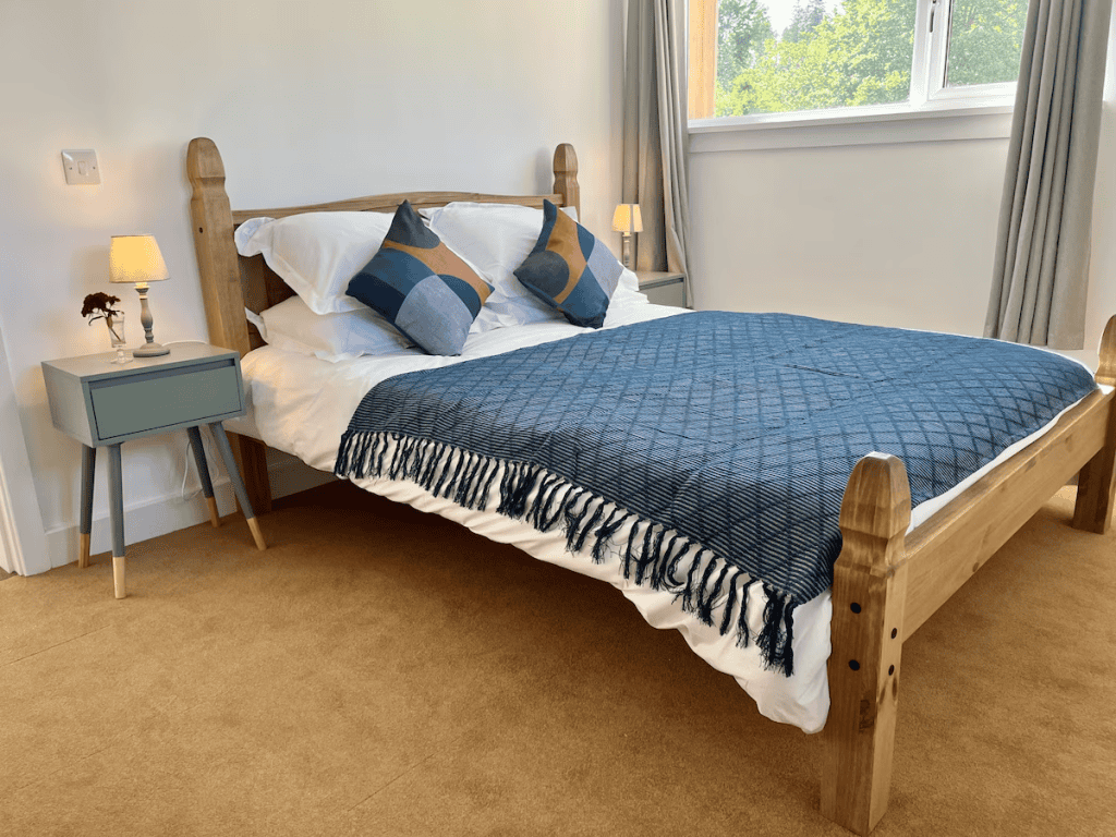 Cozy bedroom with wooden bed and blue bedding