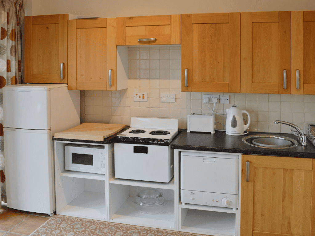 Small kitchen with wooden cabinets and various appliances