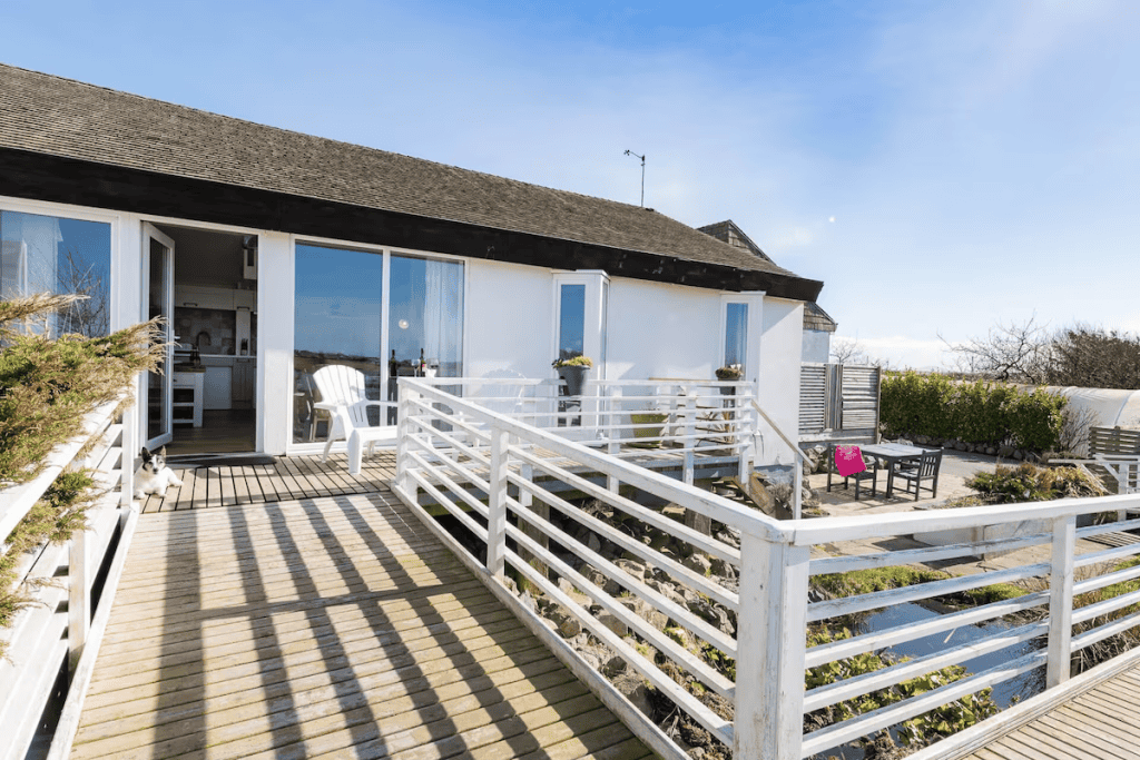 Sunny beach house with deck and white railing