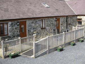 Stone cottage with wooden deck and flower planters