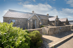 Stone cottage with gabled roofs under sunny sky