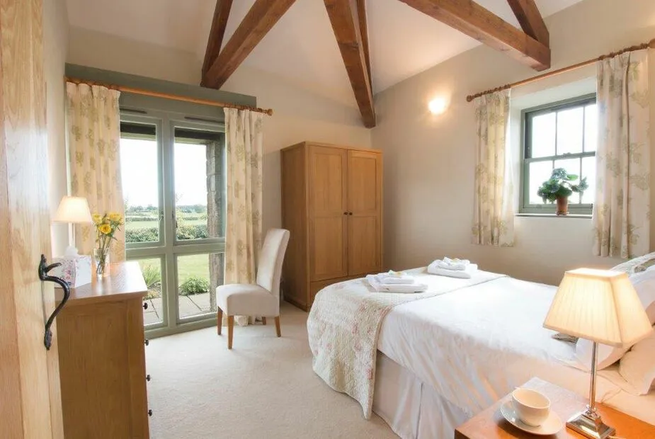 Cozy bedroom with wooden beams and scenic window view