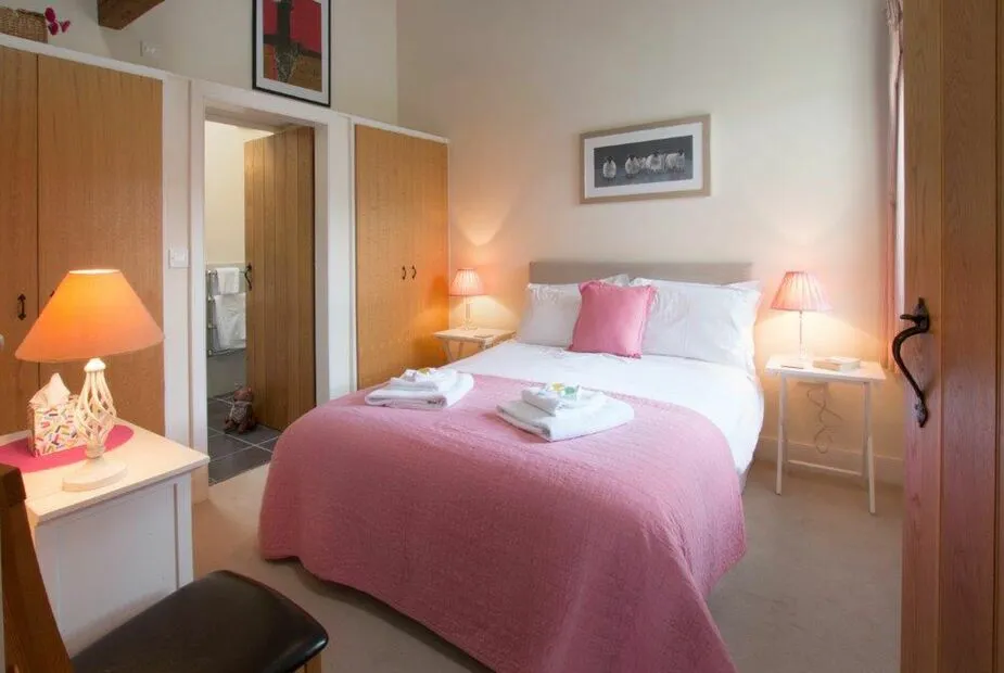 Cozy bedroom with pink bedspread and tasteful decor