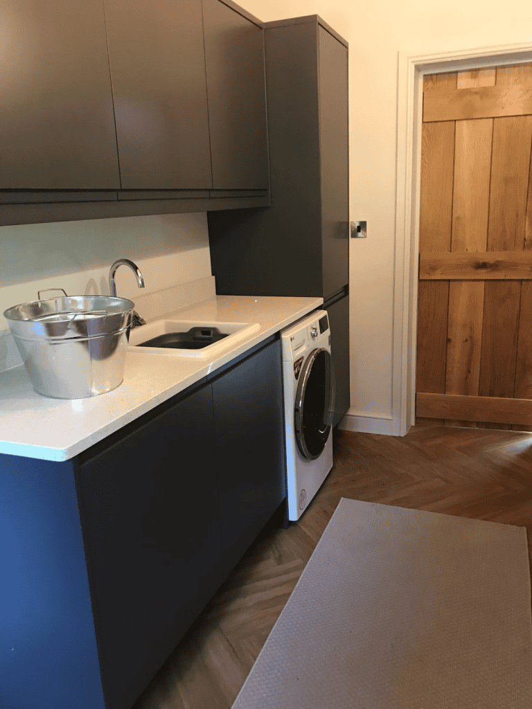 Modern kitchen with washing machine and wooden door