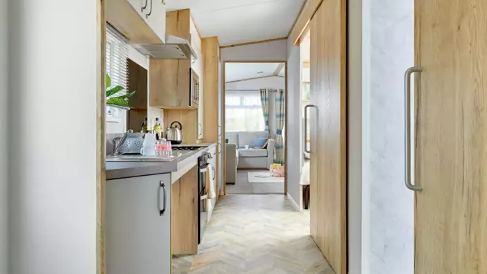Compact modern kitchen leading to bright living area