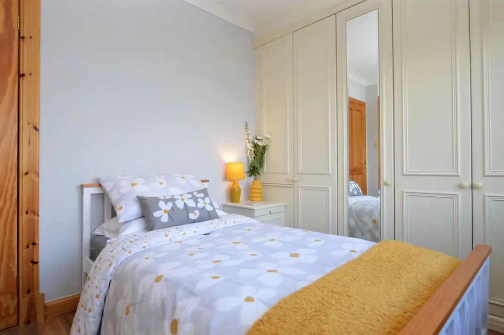 Cozy bedroom with floral bedding and wooden furniture