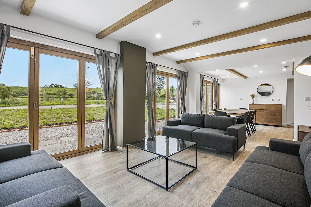 Open plan living area with large sofas and dining table ovrlooking the garden
