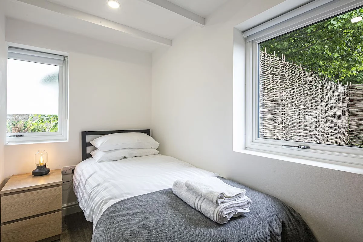 Singe bed with space to the side of the bed and the foot of the bed