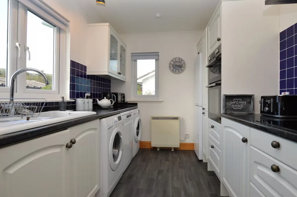 Modern kitchen with white cabinets and blue tiles