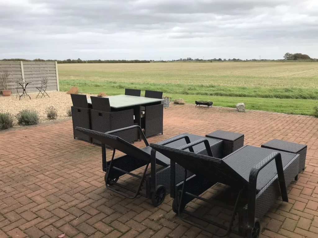 Level patio area with sun loungers and table and chairs