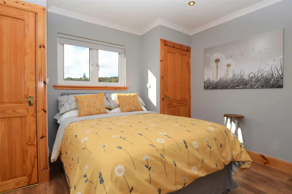 Sunny bedroom with yellow floral bedding and wooden doors