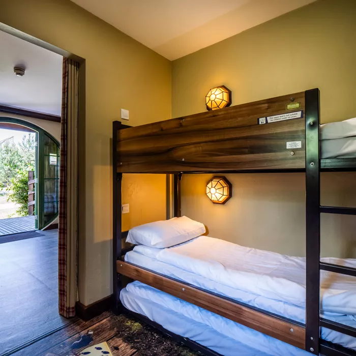 Cozy bunk beds in a well-lit bedroom with open door