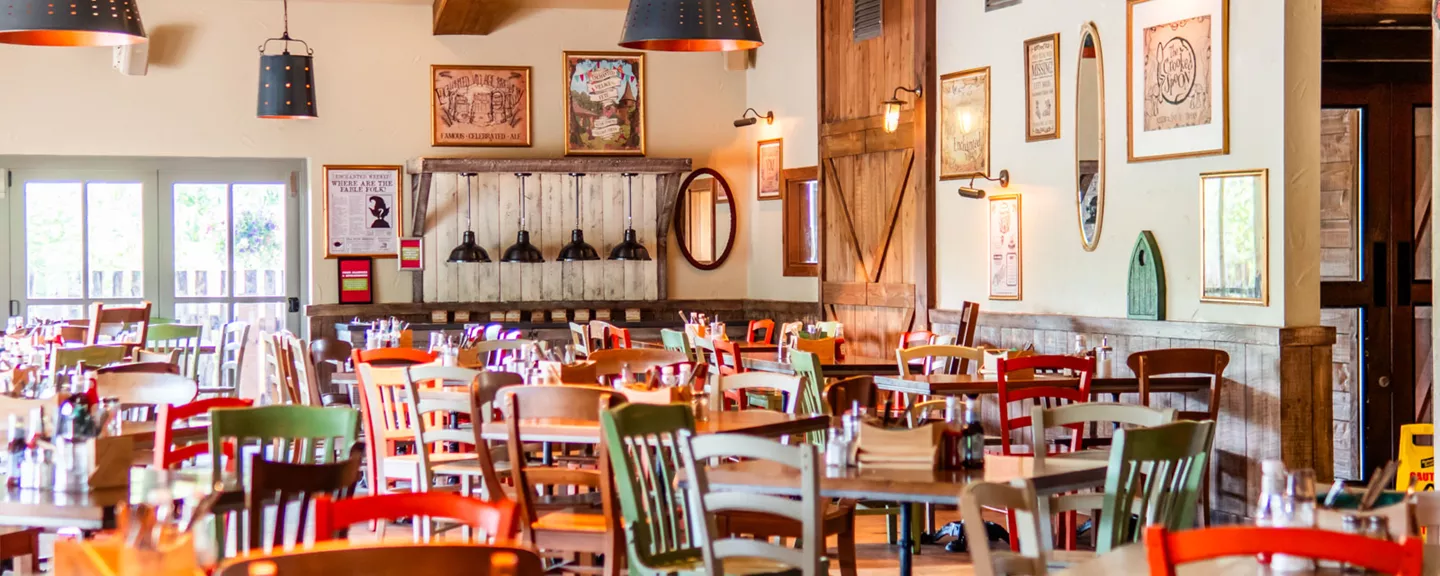 Colorful rustic restaurant interior with multiple tables and chairs.