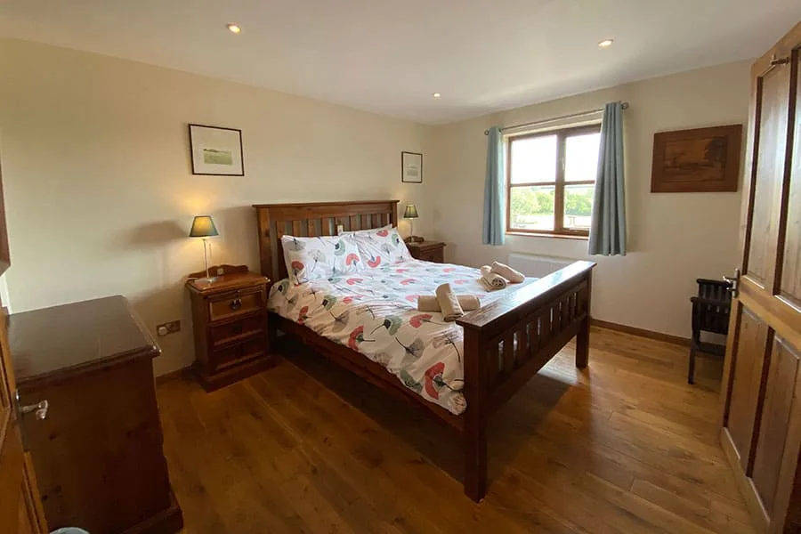 Cozy bedroom with large bed and wooden furniture
