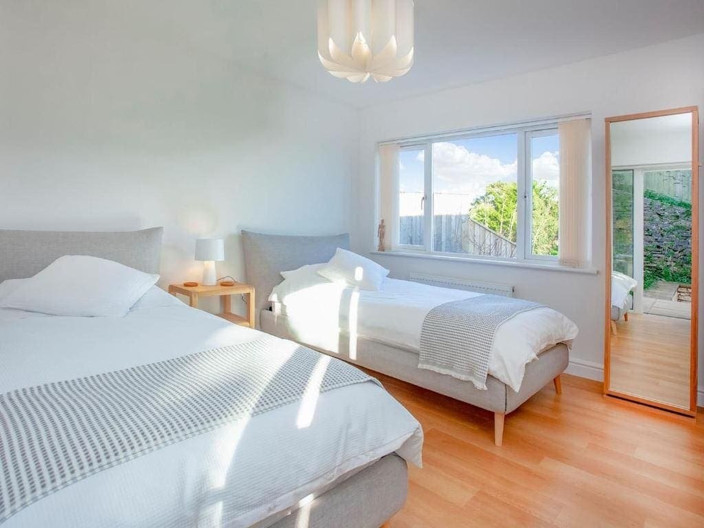 Bright modern bedroom with large window and garden view