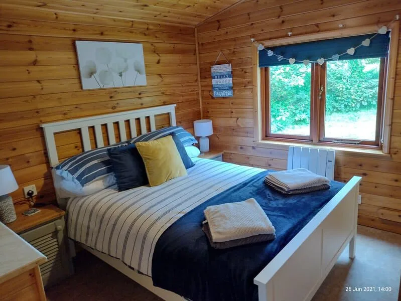 Cozy wooden cabin bedroom with stylish striped bedding