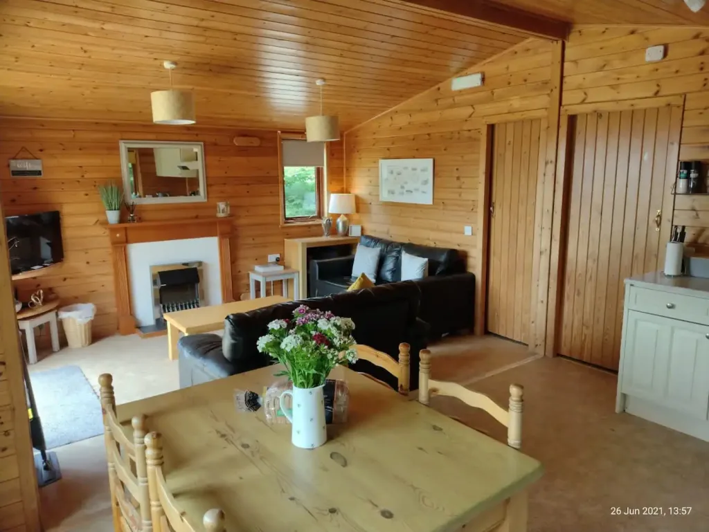 Cozy wooden cabin interior with fireplace and seating area.