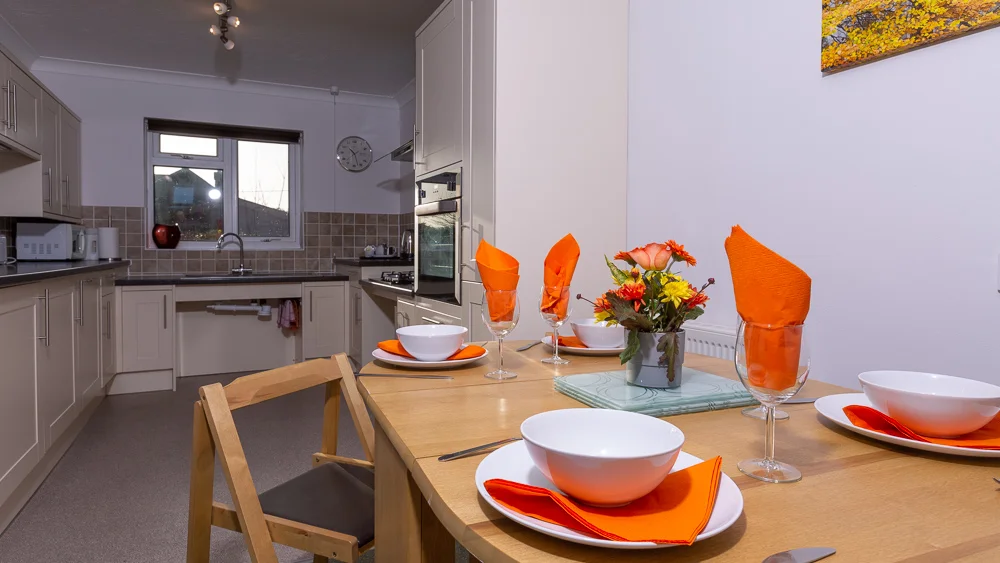 Modern kitchen with orange-themed dining setup