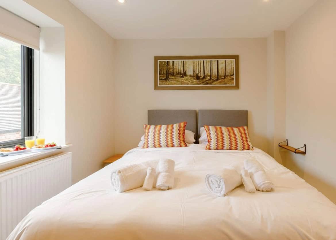 Bright bedroom with colorful pillows and scenic window view