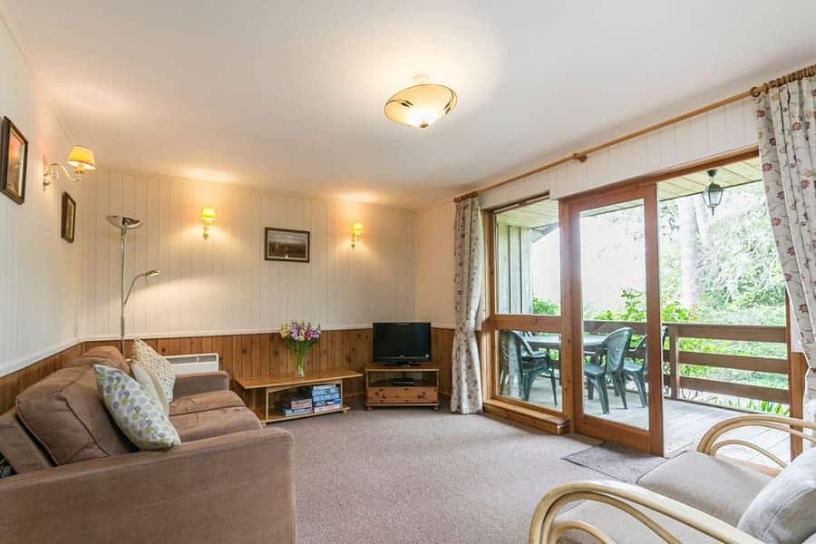 Cozy living room with TV and access to a deck