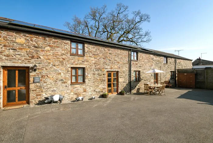 Sunny courtyard of stone-built rural barn conversion.