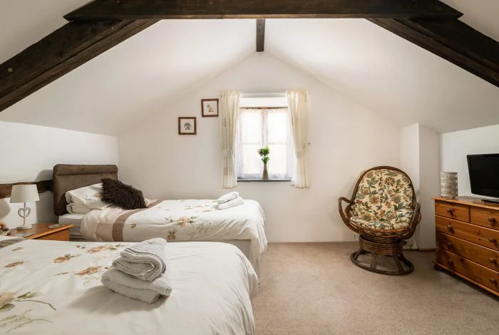 Cozy attic bedroom with twin beds and wooden furniture