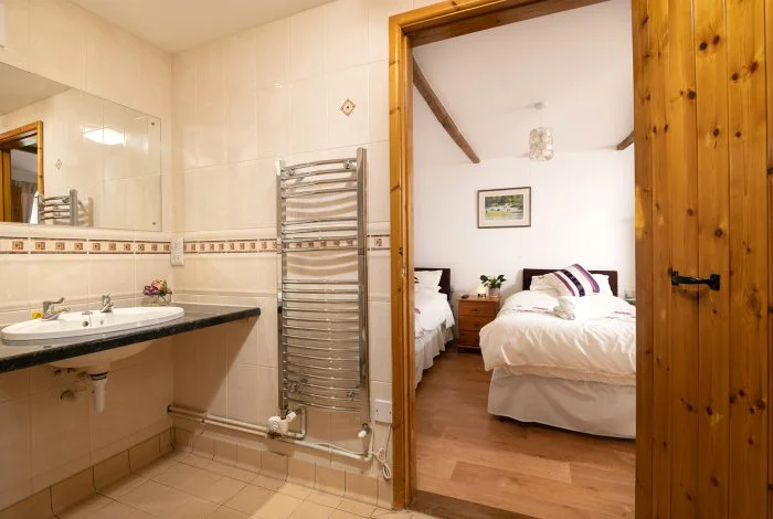 Cozy bedroom viewed from adjoining tiled bathroom