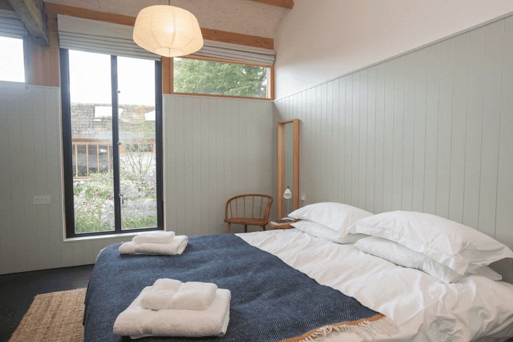 Cozy minimalist bedroom with garden view and wooden accents