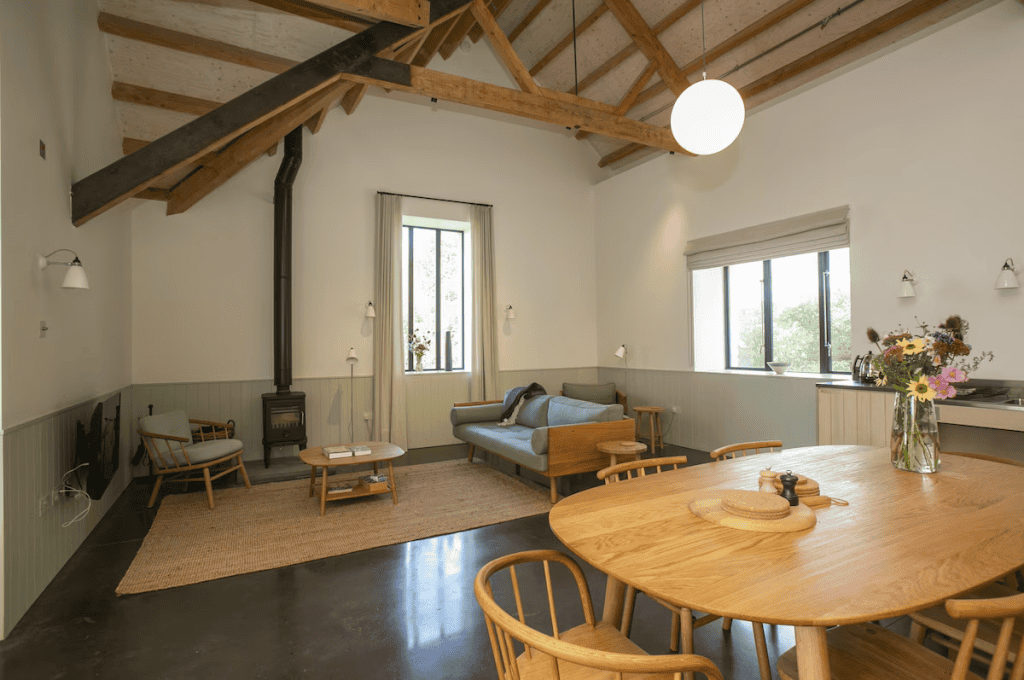 Spacious rustic living room with exposed beams and wood furniture