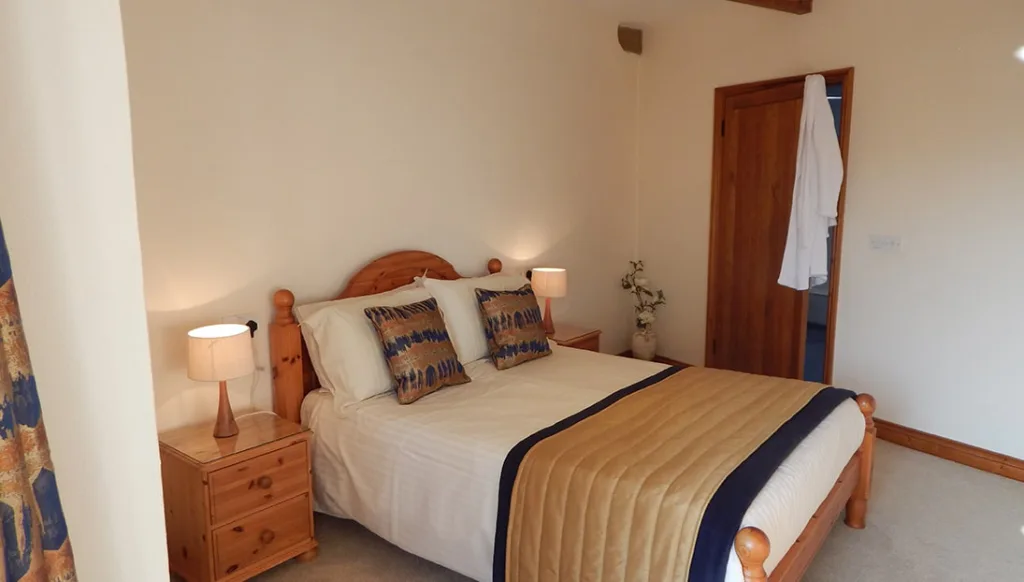 Cozy bedroom with wooden double bed and white linens