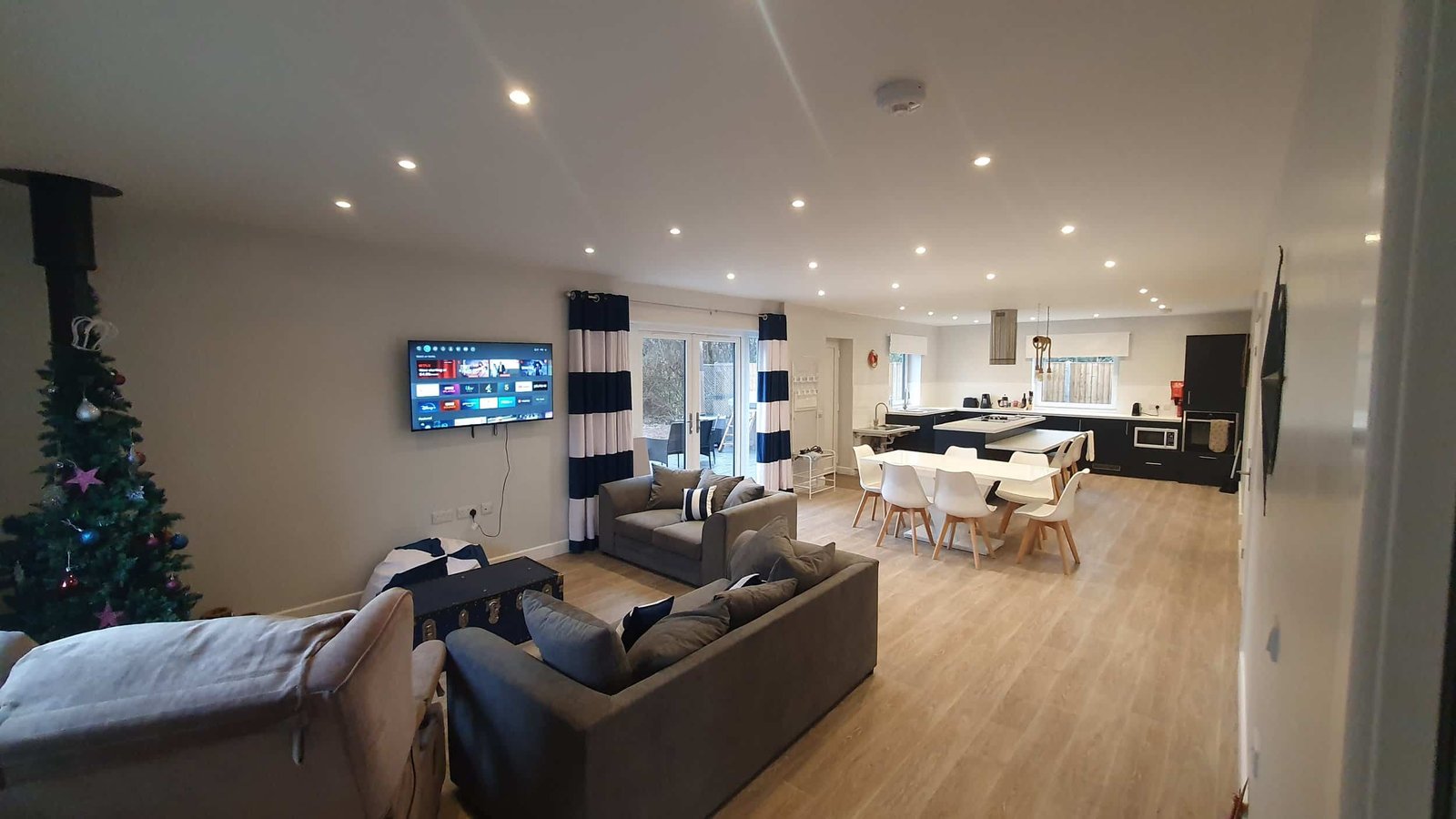 Modern open-plan living room and kitchen with Christmas tree